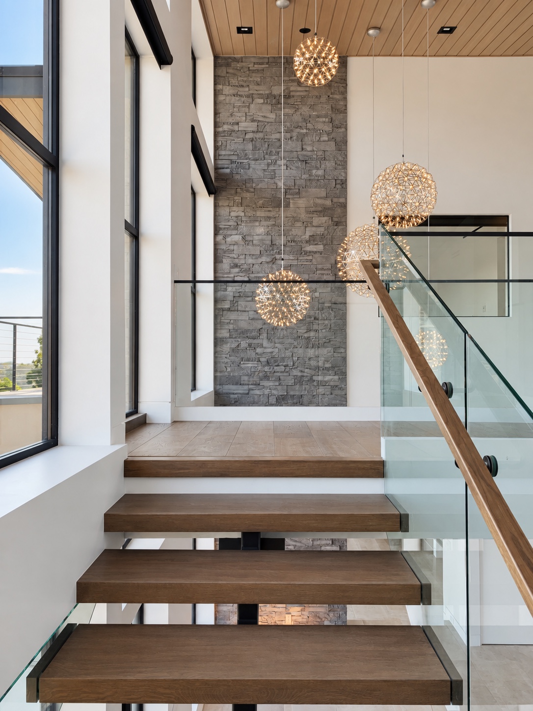 Wood stair treads, glass railing, and a stone wall — Diamond Bar, CA